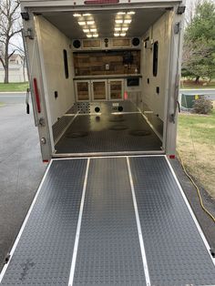 the back end of an enclosed vehicle parked in a parking lot with its door open