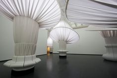 an art gallery with white sculptures on the floor