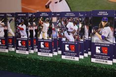 baseball cards are lined up on the wall in front of a large screen with images of players