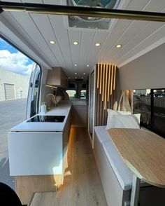 the inside of a camper with wood flooring and white counter tops on it