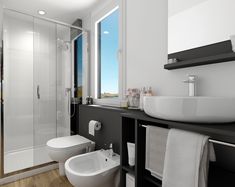 a white sink sitting next to a toilet in a bathroom near a shower and window