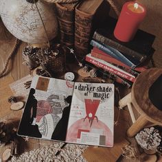 an open book sitting on top of a wooden table next to other books and decorations