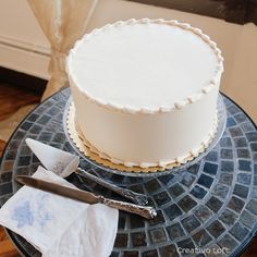 a white frosted cake sitting on top of a table