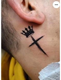 a man with a crown tattoo on his neck and behind the ear is a cross