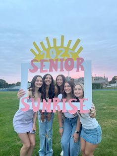 four girls holding up a sign that says senior sunrise