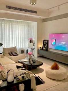 a living room filled with furniture and a flat screen tv mounted to the side of a wall