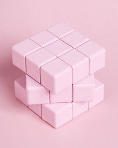 a pile of white cubes sitting on top of a pink table next to each other