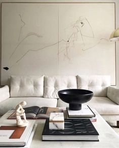 a living room with a white couch and black bowl on the coffee table in front of it