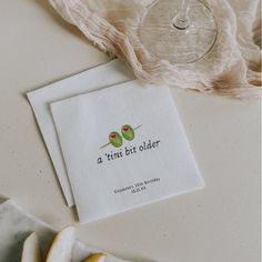 two napkins sitting on top of a table next to a wine glass and fruit