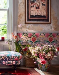 a room filled with lots of flowers next to a painting on the side of a wall