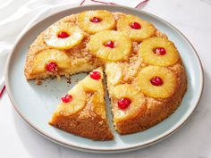 a pineapple upside down cake on a plate with one slice cut out and ready to be eaten