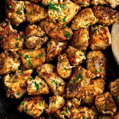 chicken with parsley in a skillet and a wooden spoon on the side, ready to be cooked