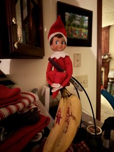 an elf is sitting on top of a banana in the living room with other items