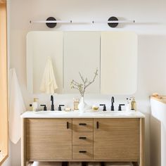 a bathroom with two sinks and mirrors on the wall