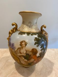 a vase with an image on it sitting on a marble counter top next to a wall