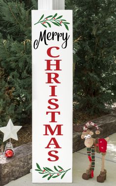 a merry christmas sign next to a tree