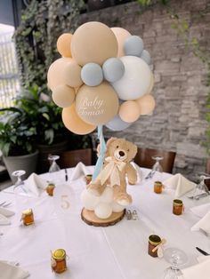 a teddy bear holding balloons on top of a table