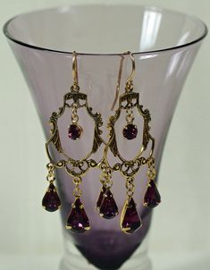 "Vintage Victorian delicate filigree reproduction connectors with three amethyst Swarovski teardrops and the center round dangling rhinestone. Wonderful sparkle and rich purple color. The earrings dangle 1 5/8\" (40 mm) from the ends of gold-filled, nickel free ear wires. You'll love these beauties for your wardrobe, especially when 12 additional Swarovski colors available. Surprisingly light in weight and elegant in appearance. Great for weddings, bridesmaids, and any dressy occasions. Here are Elegant Gold Amethyst Chandelier Earrings, Elegant Gold Chandelier Earrings With Amethyst, Vintage Earrings Victorian, Chandelier Earrings Gold, Purple Chandelier, Gold Filigree Earrings, Antique Locket, Filigree Earrings, Boho Pendant