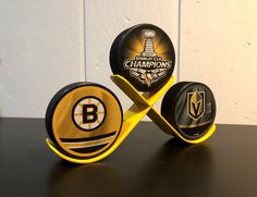 two black and yellow pucks sitting on top of a table next to each other