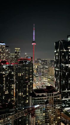 the city skyline is lit up at night with skyscrapers in the foreground and lights on