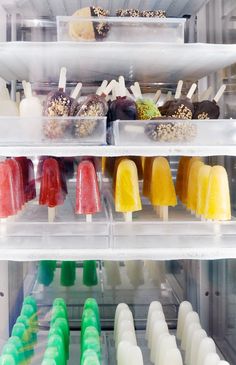 an assortment of ice creams and popsicles on display in a freezer case