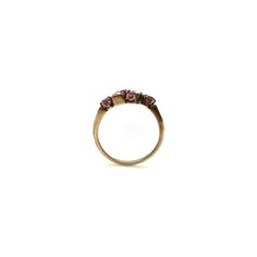 This is part of Chairish’s Fine Jewelry assortment.  A lovely Victorian ring with classic motifs that are feminine and delicate. This 14k gold band mirrors itself and meets at the centre in a cluster of gemstones—a milky white seed pearl flanked by two rubies. The gemstones are prong set, with the pearls housed in geometric squares that offset the femininity of the piece. The rubies are natural, which can be seen in the slight inclusions of the stones. They are very vibrant, and the craftsmanshi Elegant Cluster Rings With Gemstone Accents, Elegant Multi-stone Stackable Rings, Timeless Multi-stone Wedding Rings, Timeless Wedding Rings With Multi-stones, Elegant Multi-stone Cluster Birthstone Ring, Elegant Multi-stone Cluster Promise Ring, Elegant Yellow Gold Cluster Ring With Gemstone Accents, Elegant 14k Gold Cluster Ring With Gemstone Accents, Elegant Multi-stone Round Band Rings