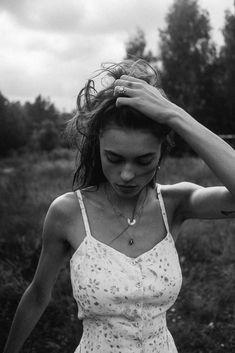 black and white photograph of a woman with her hair blowing in the wind while wearing a dress