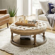 a living room filled with furniture and a coffee table on top of a rug in front of a window