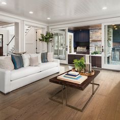 a living room with white furniture and wood floors