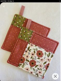 three pieces of fabric sitting on top of a white table covered in pink and green flowers