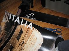 a pair of skis sitting on top of a wooden floor next to a black dog