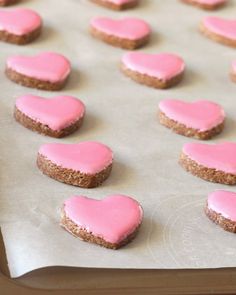 pink heart shaped cookies are on a baking sheet and ready to be baked in the oven