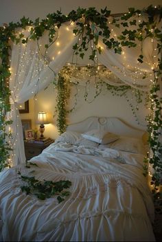 a bed covered in vines and lights next to a night stand