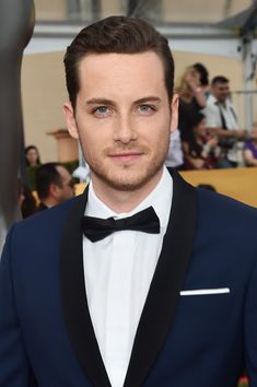 a man in a tuxedo and bow tie posing for the camera at an event