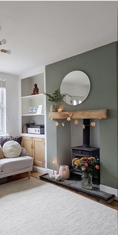 a living room filled with furniture and a fire place in front of a mirror on the wall