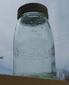 a mason jar sitting on top of a wooden table next to a telephone wire pole