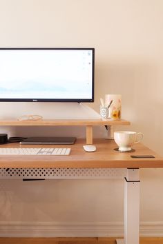 a computer monitor sitting on top of a wooden desk next to a keyboard and mouse