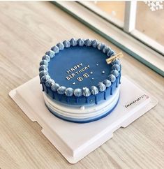 a blue birthday cake sitting on top of a white plate with the words happy birthday written on it