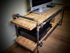 a computer monitor sitting on top of a wooden shelf next to a keyboard and mouse