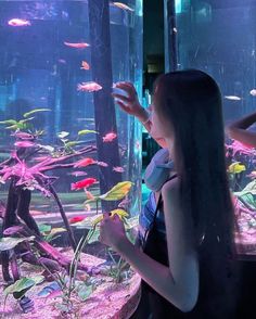 two girls looking at fish in an aquarium