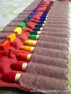 a row of crayons sitting on top of a red cloth