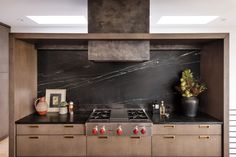 a stove top oven sitting inside of a kitchen next to a wall mounted range hood