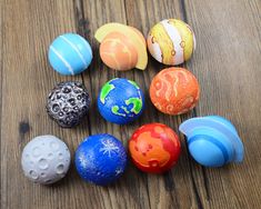 an assortment of different colored plastic balls on a wooden surface with holes in the middle