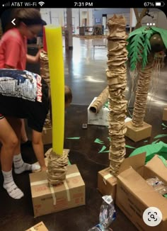 two people are sitting on cardboard boxes with palm trees in the background