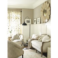 a living room filled with furniture and a large mirror on the wall above it's headboard