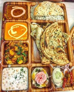 a wooden tray filled with lots of different types of food on top of each other