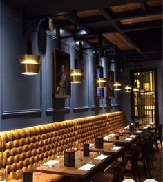 an empty restaurant with blue walls and yellow leather booths on either side of the tables