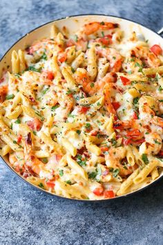 a skillet filled with pasta and shrimp