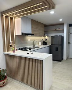 a modern kitchen with an island counter top and stainless steel appliances in the center, along with potted plants on the side