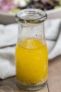 a glass jar filled with liquid sitting on top of a wooden table